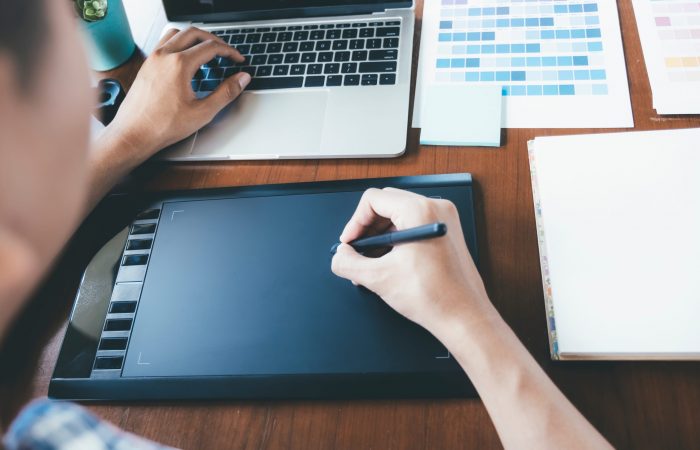 Graphic designer and Photographer working on computer and used graphics tablet.